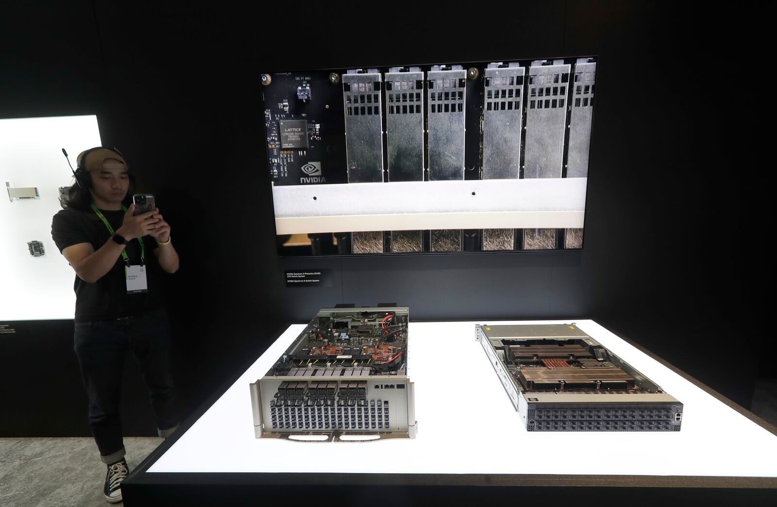 A member of staff takes a photo to Nvidia Quantum-X Photonics Q3450 CPO Switch System during the Computex 2025 exhibition in Taipei, Taiwan, Wednesday, May 21, 2025. (AP Photo/Chiang Ying-ying)