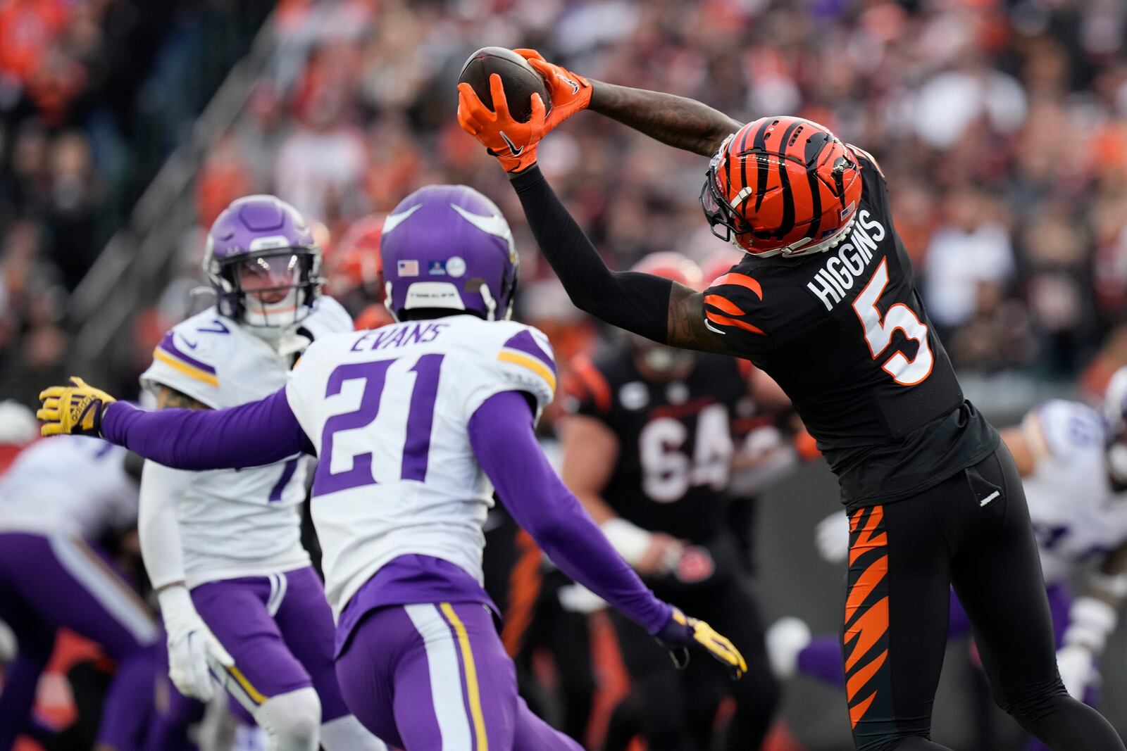 Cincinnati Bengals wide receiver Tee Higgins (5) makes a catch in front of Minnesota Vikings cornerback Akayleb Evans (21) during the second half of an NFL football game Saturday, Dec. 16, 2023, in Cincinnati. (AP Photo/Carolyn Kaster)
