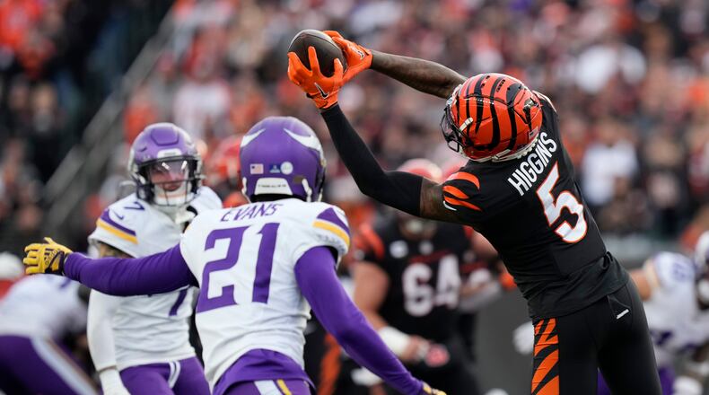 Cincinnati Bengals wide receiver Tee Higgins (5) makes a catch in front of Minnesota Vikings cornerback Akayleb Evans (21) during the second half of an NFL football game Saturday, Dec. 16, 2023, in Cincinnati. (AP Photo/Carolyn Kaster)