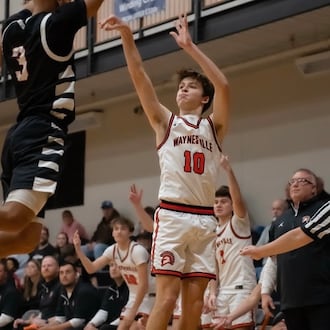 Waynesville coach Brandon Philpot (right) watches as junior Ross Barrett fires up a shot during a recent game. CARSON HALE / CONTRIBUTED