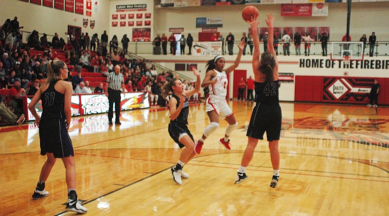 Lakota West’s Bryana Henderson (1) tries to send a pass over Northwestern’s Allison Miller (42) during Saturday night’s Journey to the Tourney contest at West. The host Firebirds won 61-53. RICK CASSANO/STAFF