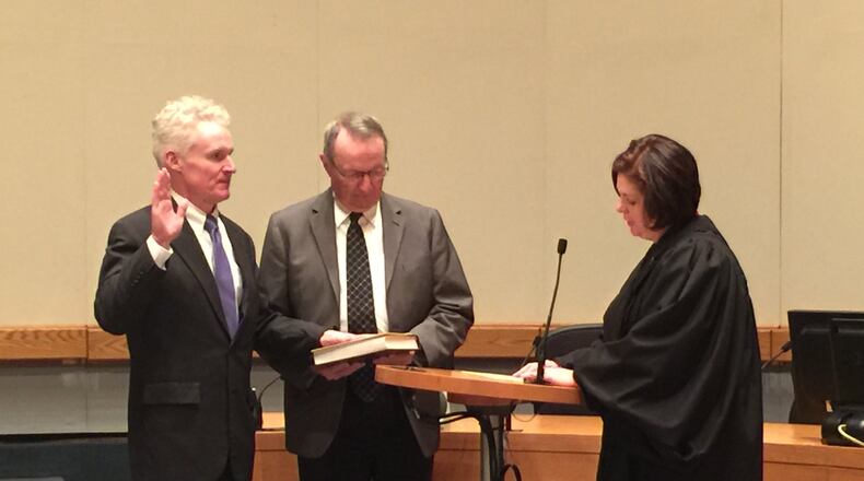 Middletown City Councilman-elect Joe Mulligan, left, takes his oath of office as his father Larry Mulligan, center, holds a family Bible. The ceremony followed the 2017 State of the City address on Dec. 12 by his brother, Middletown Mayor Larry Mulligan Jr. ED RICHTER