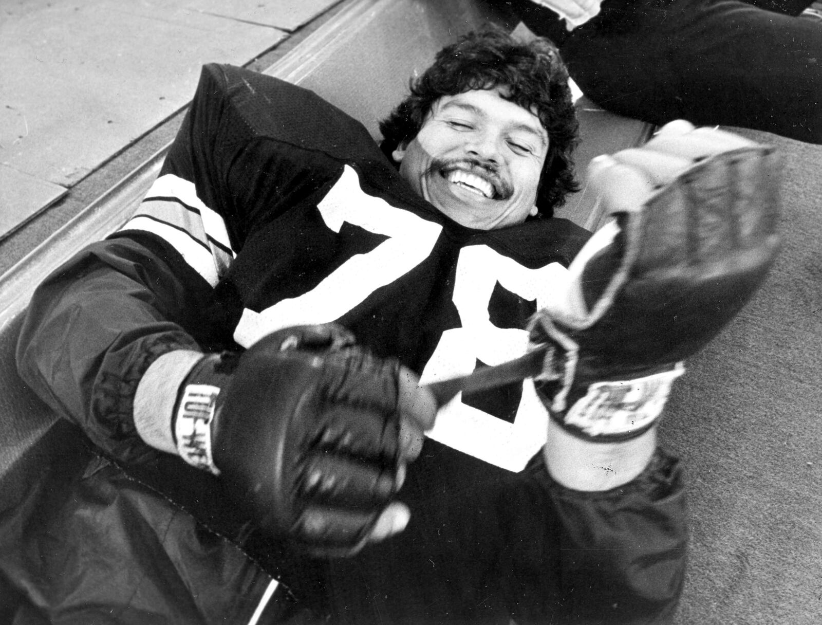 FILE - Cincinnati Bengals tackle Anthony Munoz tightens his glove before an NFL football practice session at the Silverdome in Pontiac, Mich., Jan. 23, 1982. Players from the 1988 Bengals Super Bowl team are reveling the success in the current team, which is playing in the AFC championship game Sunday, Jan. 30, 2022, in Kansas City. (AP Photo/File)
