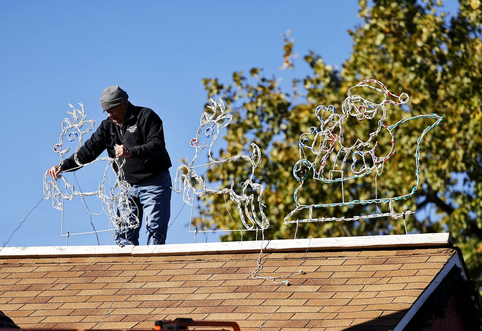 Jack Squier installs lights on top of Santa's shed Tuesday, Oct. 21 at Smith Park in Middletown. Squier is part of a group of retirees known as the Grandpa Gang who install displays for Light Up Middletown. NICK GRAHAM/STAFF