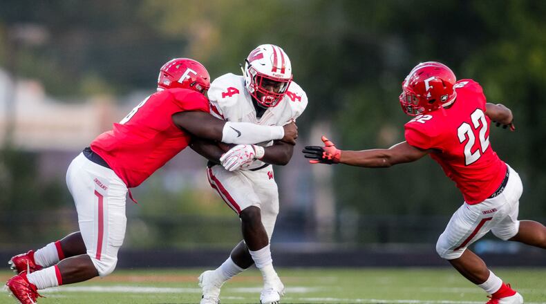 Lakota West’s David Afari carries the ball and is surrounded by Fairfield’s Greg Fitzpatrick (left) and Dealo McIntosh during Sept. 14 game at Fairfield Stadium. Fairfield won 37-3. NICK GRAHAM/STAFF