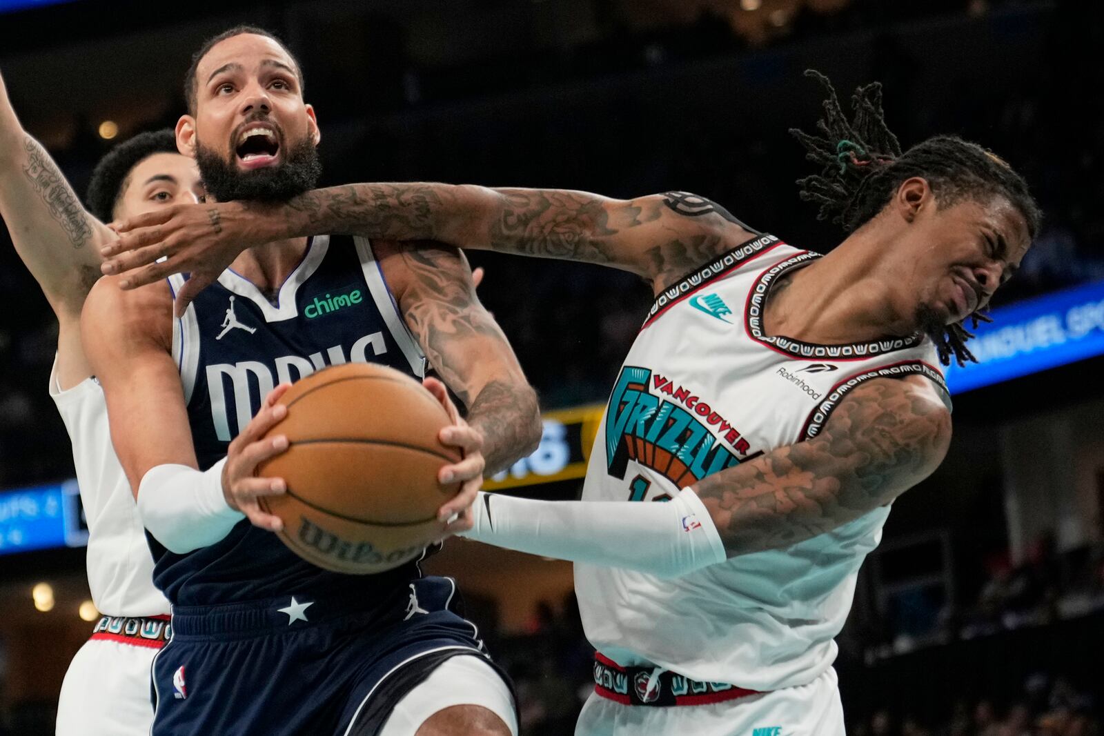 Dallas Mavericks forward Caleb Martin, left, and Memphis Grizzlies guard Ja Morant, right, collide during the second half of an NBA play-in tournament basketball game Friday, April 18, 2025, in Memphis, Tenn. (AP Photo/George Walker IV)