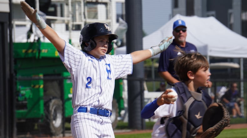 West Side Little League's Jordan Malloy signals a safe call after sliding into home during his Great Lakes Region game against Kentucky on Saturday at the Little League Central Region Complex in Whitestown, Indiana. West Side won 7-0. CHRIS VOGT / CONTRIBUTED
