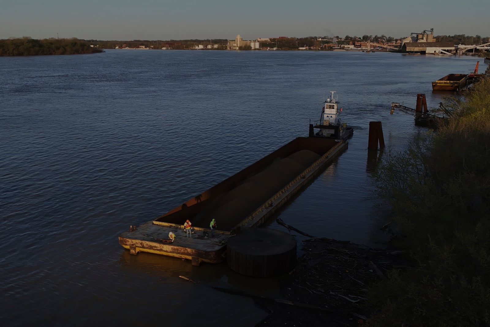 A crew works on a coal barge Tuesday, April 8, 2025, in Evansville, Ind. (AP Photo/Joshua A. Bickel)