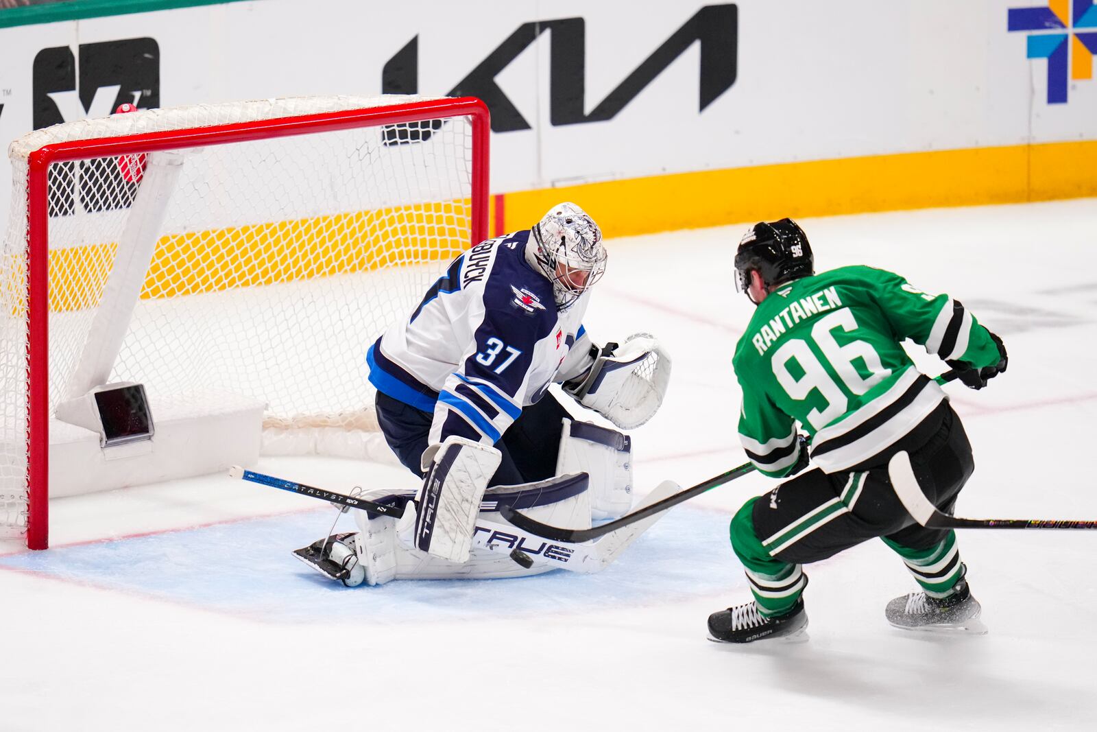 Winnipeg Jets goaltender Connor Hellebuyck (37) blocks a shot by Dallas Stars right wing Mikko Rantanen (96) during the third period of an NHL hockey game Thursday, April 10, 2025, in Dallas. (AP Photo/Julio Cortez)