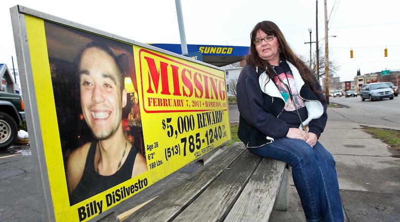 Debbie Winkler Estes sits on a bench with information about her son Billy DiSilvestro, who has been missing since 2011. Estes has become a supporter to many other local families who have loved ones that are missing. STAFF/FILE PHOTO