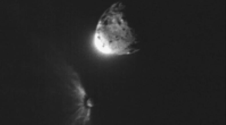 In this image provided by NASA, an impact plume emerges from the asteroid Dimorphos, left, after DART collides into it on Sept. 26, 2022, orbiting the larger asteroid Dimorphos. (NASA/ASI/University of Maryland/Tony Farnham/Nathan Marder via AP)