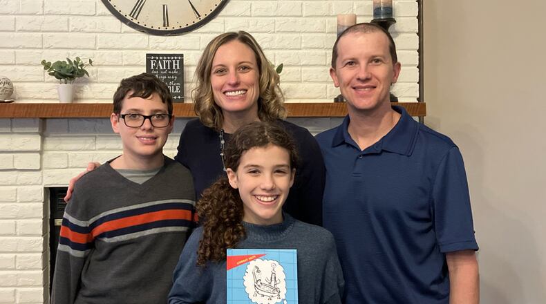 Local author Lindsey Hilty is seen with her family. her daughter is holding her book, "Do You Have To Take Showers in Heaven? And Other Kid Questions About Our Forever Home With God”. CONTRIBUTED