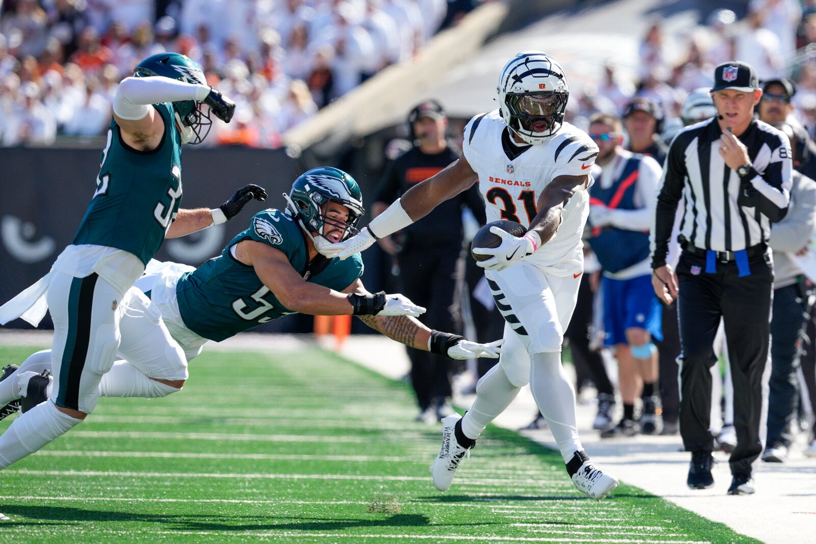 Cincinnati Bengals running back Zack Moss (31) is pushed out of bounds by Philadelphia Eagles linebacker Zack Baun, center, and safety Reed Blankenship, left, during the first half of an NFL football game, Sunday, Oct. 27, 2024 in Cincinnati. (AP Photo/Jeff Dean)