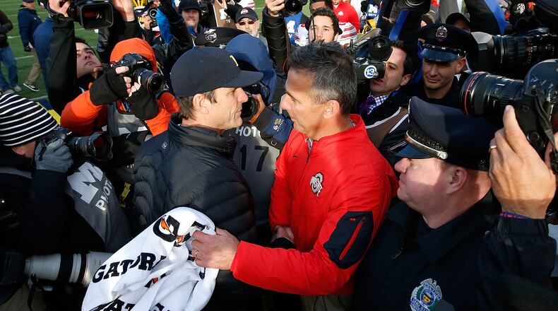 ANN ARBOR, MI - NOVEMBER 28:  Head coach Urban Meyer of the Ohio State Buckeyes shakes hands with head coach Jim Harbaugh of the Michigan Wolverines after a 42-13 Ohio State win at Michigan Stadium on November 28, 2015 in Ann Arbor, Michigan.  (Photo by Gregory Shamus/Getty Images)