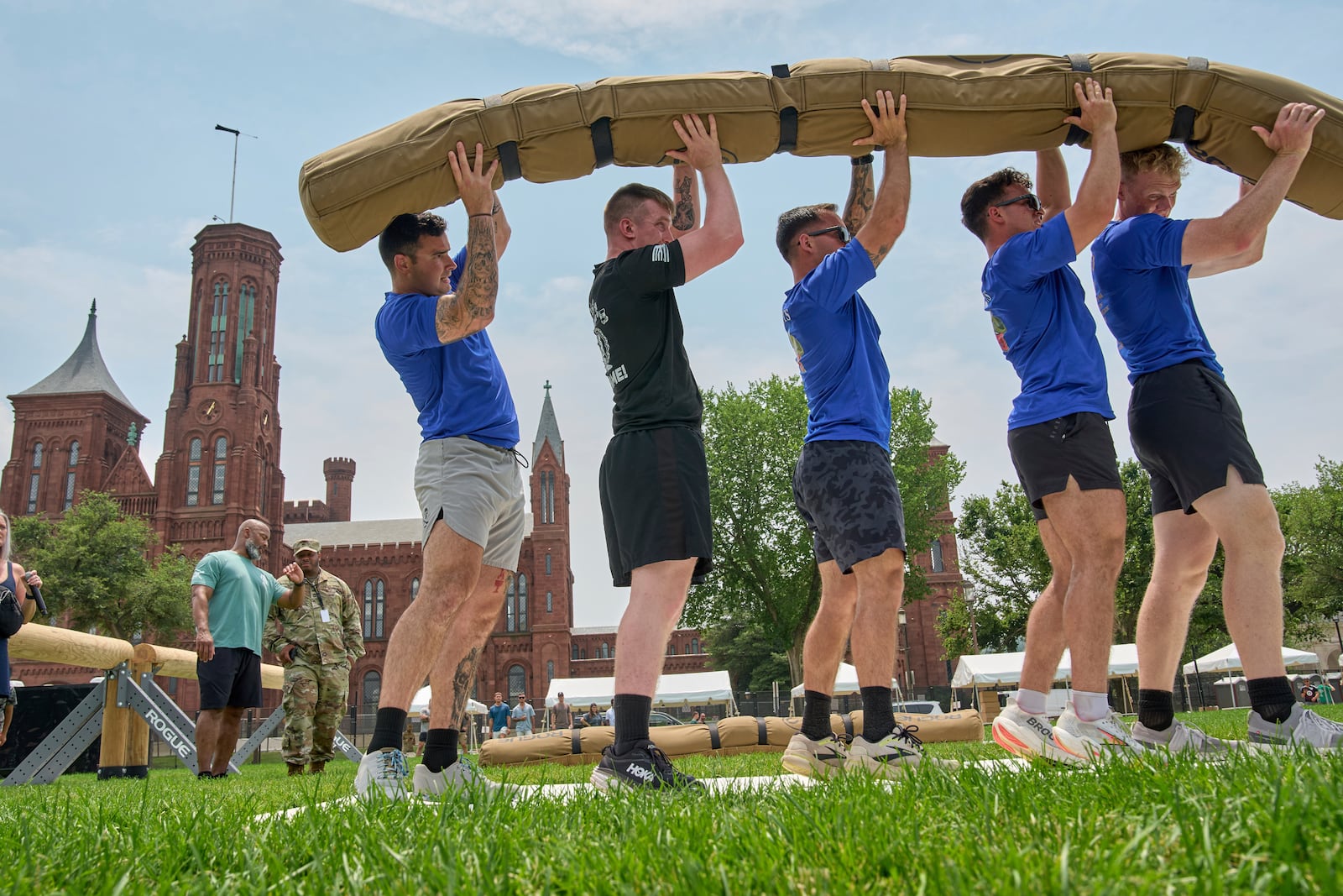 Army SSG Jason Craig, from left, Army Sgt. Blake Oakley, Army 1st Lt. Lukas Nicoloff, Army 1st Lt. Michael Ramirez and Army 1st Lt. Sean Buck lift a weighted "worm" as they practice ahead of the Army Fittest Squad competition, Friday, June 13, 2025, by the Smithsonian Castle on the National Mall in Washington, during preparations for an upcoming military parade commemorating the Army's 250th anniversary and coinciding with President Donald Trump's 79th birthday. (AP Photo/Jacquelyn Martin).