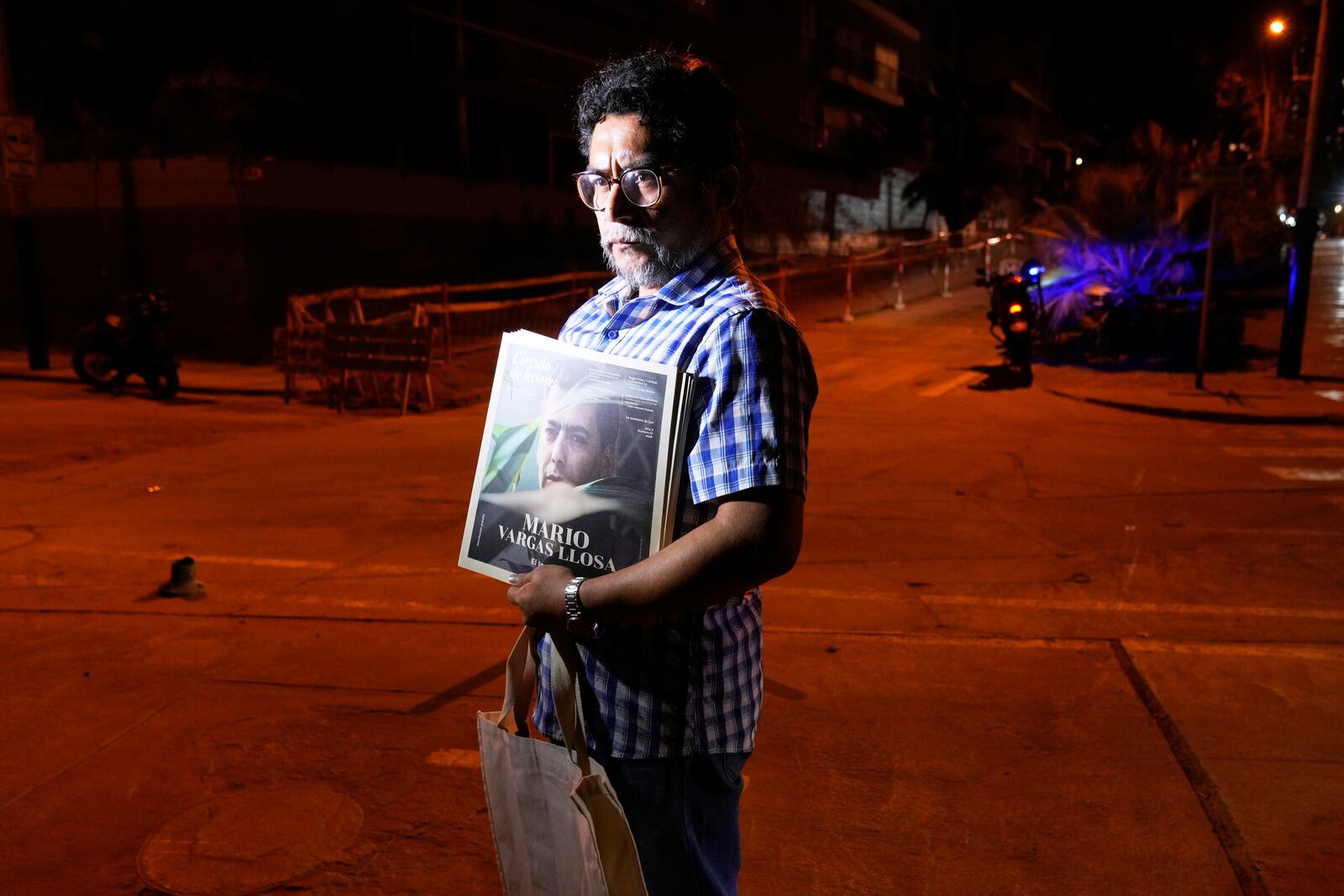 Gabriel Rimachi holds an issue of the literary magazine he directs, dedicated to Peruvian Nobel literature laureate Mario Vargas Llosa, after the announcement of the writer's death at the age of 89, in front of his home in Lima, Peru, Sunday, April 13, 2025. (AP Photo/Martin Mejia)