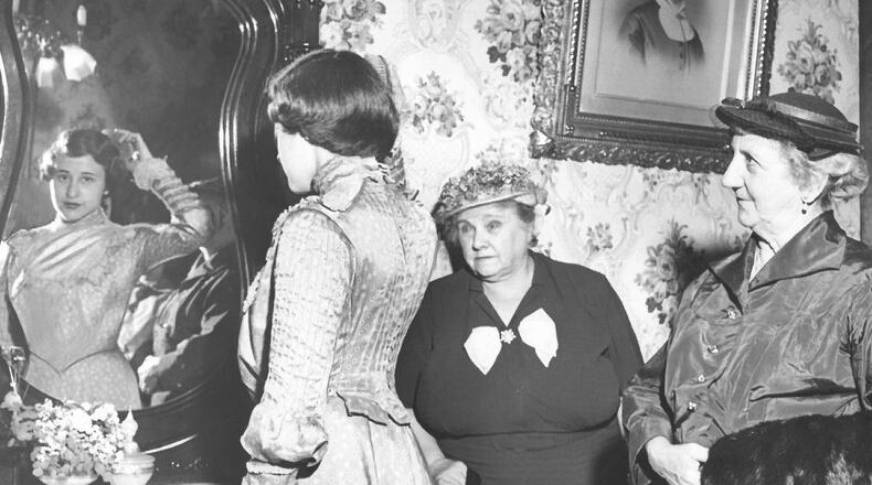 Looking in the mirror, a model shows off historical clothing in the Benninghoffen bedroom of the Butler County Historical Society, April, 1954. JOURNAL-NEWS ARCHIVE PHOTO