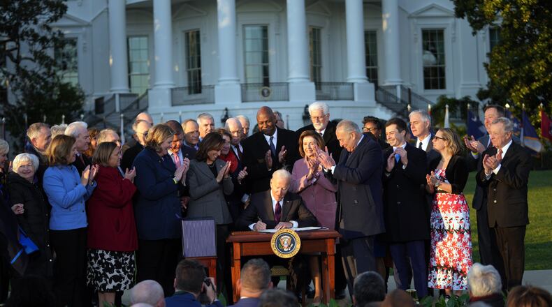 As Dayton Mayor Nan Whaley and members of Congress and other officials look on, President Joe Biden signs the $1 trillion infrastructure bill into law at the White House on Monday, Nov. 15, 2021. (Doug Mills/The New York Times)