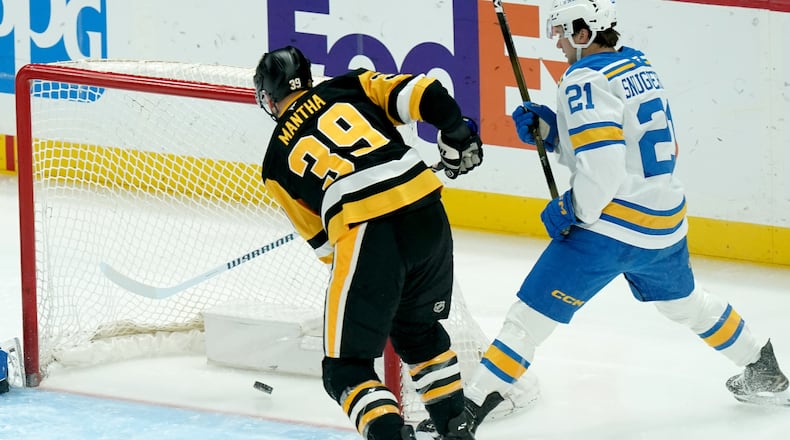 Pittsburgh Penguins' Anthony Mantha (39) scores next to St. Louis Blues' Jimmy Snuggerud (21) during the first period of an NHL hockey game, Monday, Oct. 27, 2025, in Pittsburgh. (AP Photo/Matt Freed)