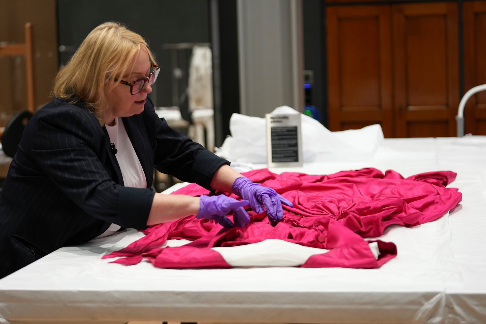 Kate Parsons, Director of Collections Care and Access, shows a dress designed and made by Cristóbal Balenciag in 1954, at the V&A Storehouse in London, Thursday, June 5, 2025. (AP Photo/Joanna Chan)