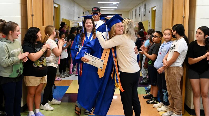 Hamilton City School's annual tradition of graduating seniors visiting their old elementary schools took place on Wednesday, May 7, 2025. The seniors walked the halls of their old schools with current students lining the walls cheering their accomplishments of graduation. Pictured senior Hazel Culver hugging Highland Elementary teacher as she and her fellow classmates paraded the halls at the Main Street elementary school. MICHAEL D. PITMAN/STAFF