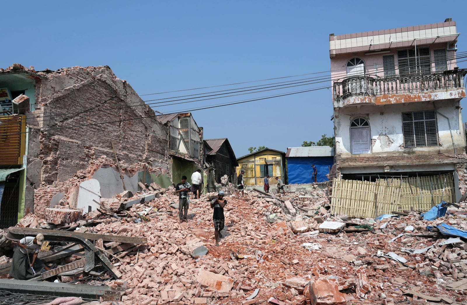 Volunteers help to clear collapsed building after one month of the strong earthquake in Naypyitaw, Myanmar, Monday, April 28, 2025. (AP Photo/Aung Shine Oo)