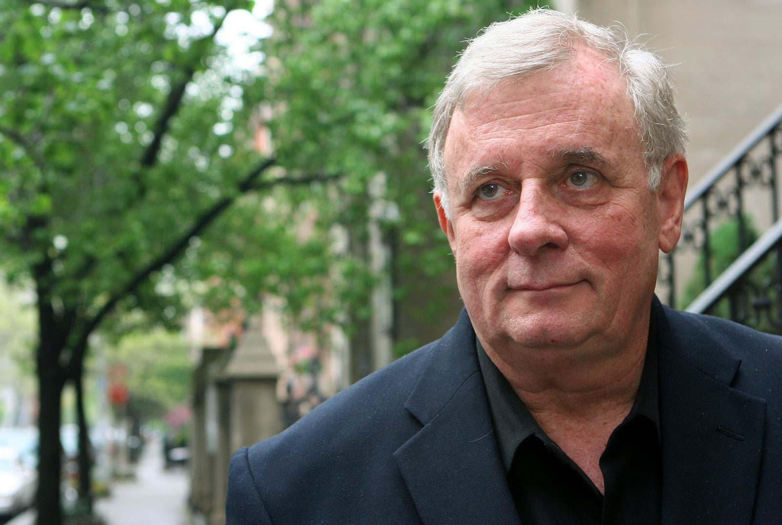 FILE - Author Edmund White stands outside his apartment April 24, 2006 in New York. (AP Photo/Mark Lennihan, file)