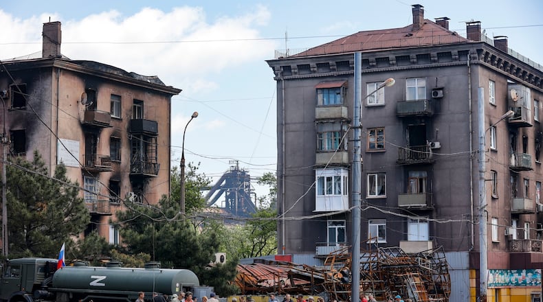 Civilians gather to receive drinking water distributed by the Russian Emergency Situations Ministry in Mariupol on May 27, 2022, after the seaside city in eastern Ukraine fell to Moscow's troops. (AP Photo, File)