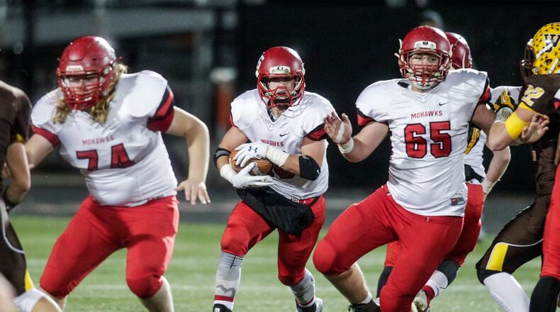 Madison’s Tyler Baumgartner carries the ball as Stephen Watts (65) and Caleb Bolen (74) block for him during their Division V, Region 20 final against West Jefferson last Friday at Beavercreek. Madison won 42-7. NICK GRAHAM/STAFF