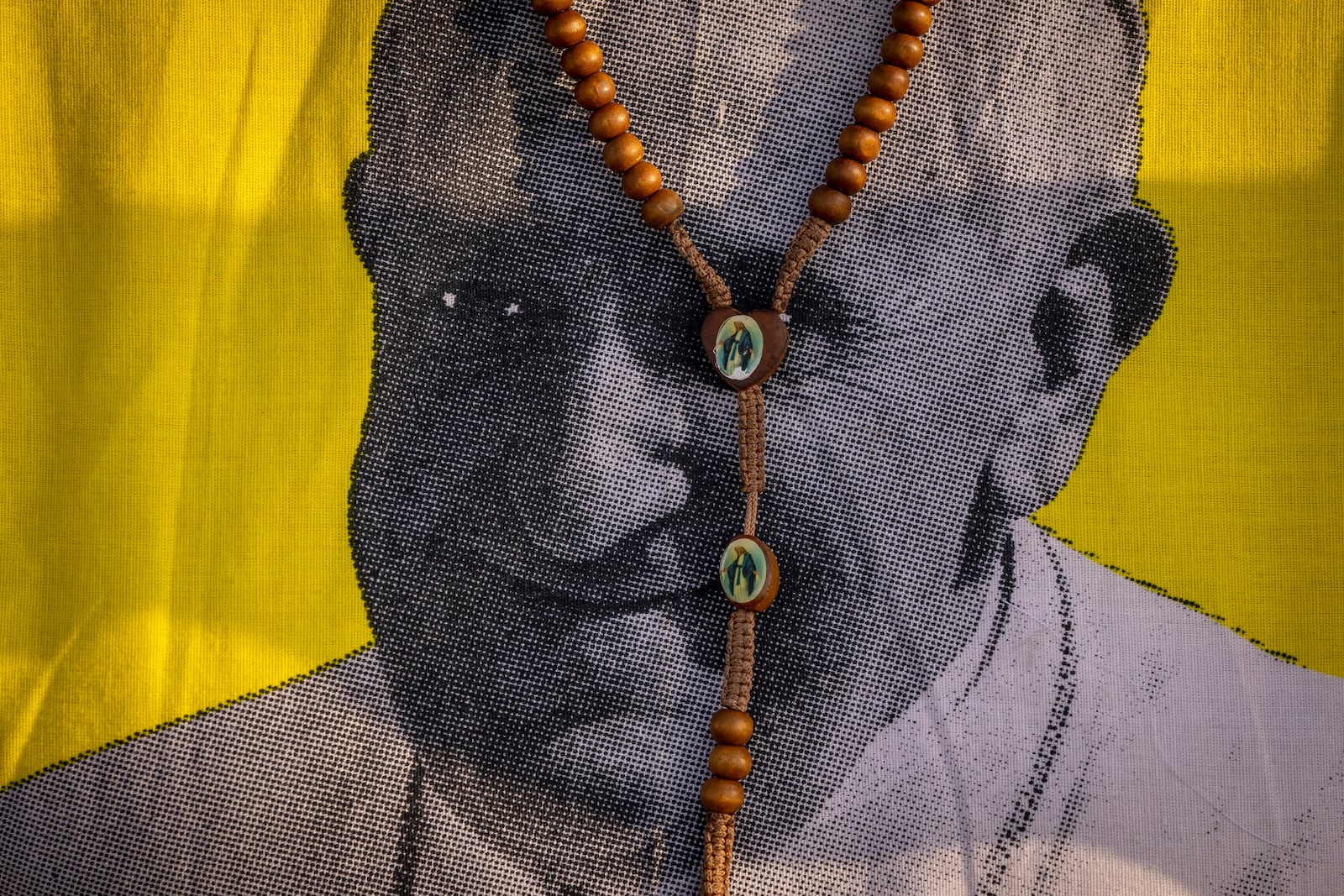 FILE - A necklace featuring the Virgin Mary hangs around the neck of a woman wearing a T-shirt of Pope Francis as she waits for his arrival at the St. Theresa Cathedral in Juba, South Sudan, Feb. 4, 2023. (AP Photo/Ben Curtis, File)