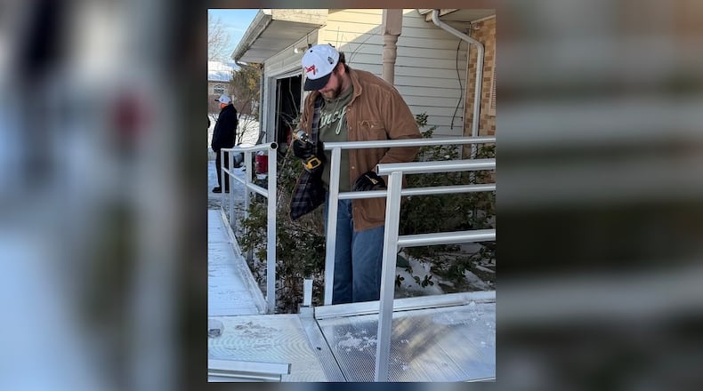 Ted Karras, a lineman for the Cincinnati Bengals, helps install a ramp for a Trenton couple last week. Karras, founder of Cincy Hats, and volunteers from Ramp It Up built the ramp just in time for Christmas. SUBMITTED PHOTO