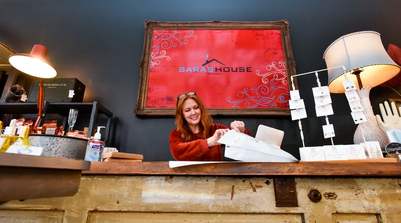 Sara Vallandingham, owner of Saraâs House in downtown Hamilton, packs up an online order for shipment Wednesday, March 18, 2020. With decreased foot traffic in the store she is trying other ways to serve her customers like shipping orders through her online store and curb-side pickup. NICK GRAHAM / STAFF