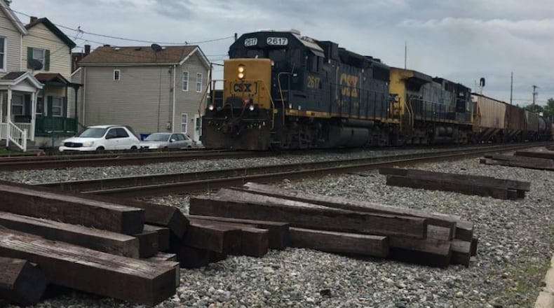 A CSX train passes through Hamilton, with wooden timbers nearby, which are some of the obstacles, including large rocks, wooden timbers and the metal train rails themselves, that make it difficult for pedestrians to walk on. MIKE RUTLEDGE/STAFF