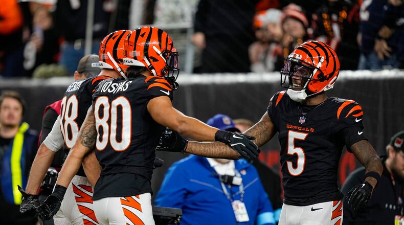 Cincinnati Bengals wide receiver Tee Higgins (5) celebrates a touchdown against the Denver Broncos with wide receiver Andrei Iosivas (80) and tight end Mike Gesicki (88) during the first half of an NFL football game in Cincinnati, Saturday, Dec. 28, 2024. (AP Photo/Carolyn Kaster)
