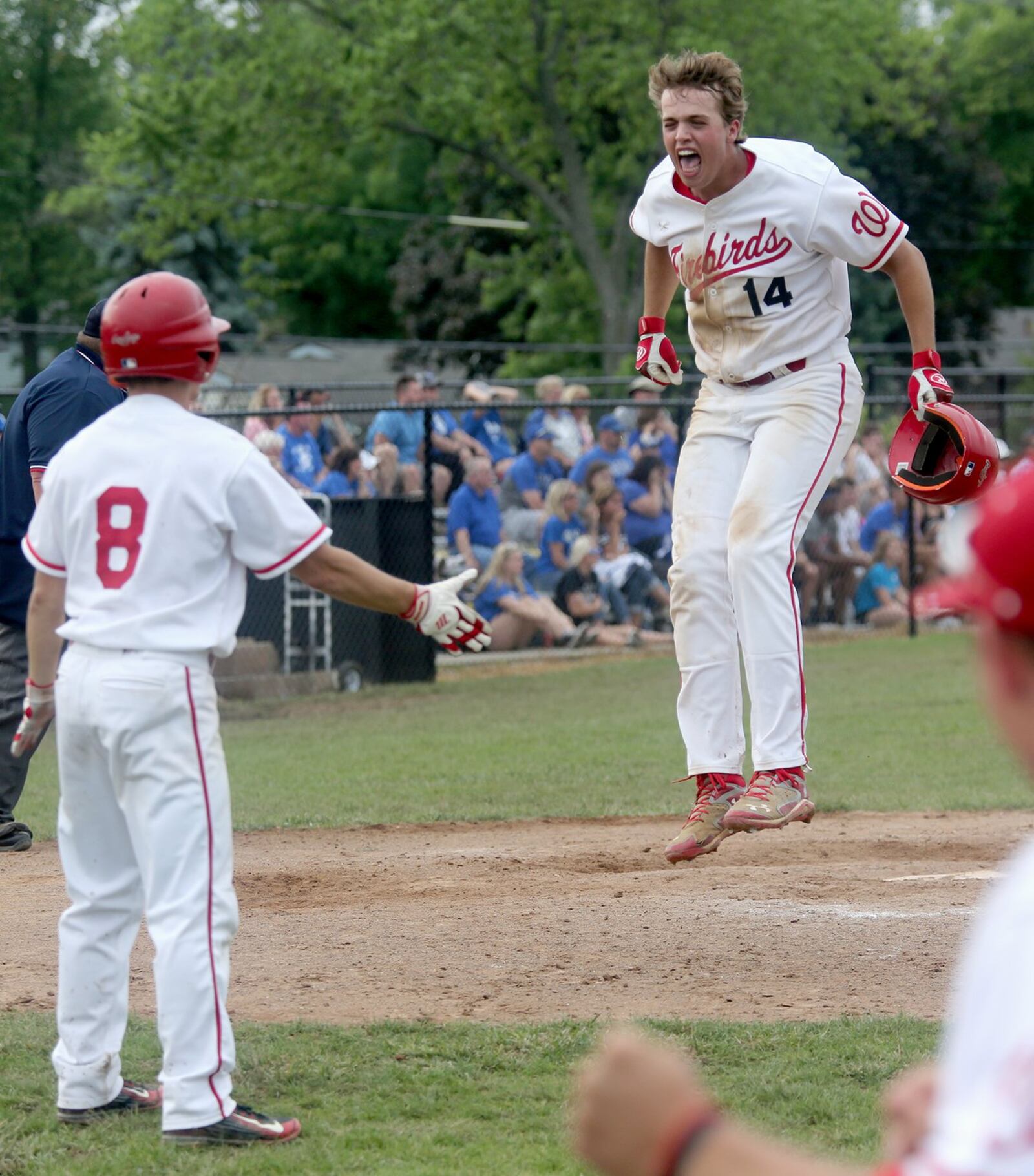 Lakota West’s Jacob Kates jumps up in front of teammate A.J. Petersen (8) after scoring the go-ahead run in the bottom of the sixth inning Saturday during a Division I district final against Springboro at Centerville. CONTRIBUTED PHOTO BY E.L. HUBBARD
