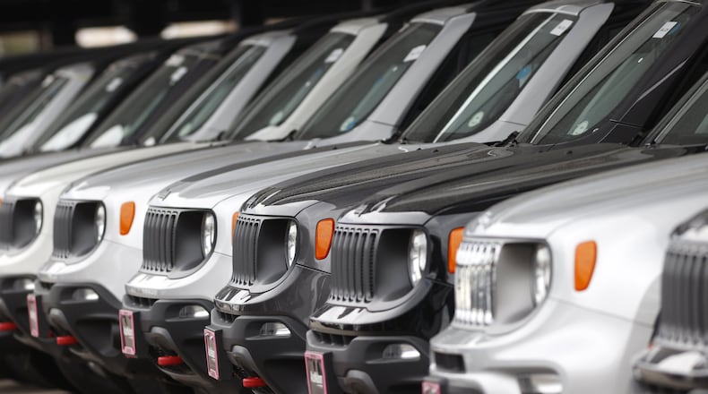 In this Sunday, April 26, 2020, photograph, a long row of unsold 2020 Renegades sits at a Chrysler/Jeep dealership in Englewood, Colo. Edmunds analysts had anticipated more than a million leased vehicles coming back to car dealerships this quarter. But due to countless shelter-in-place orders due to coronavirus concerns, many people will face the question of how to safely handle their vehicle’s lease return or whether they can return their vehicle at all. (AP Photo/David Zalubowski)