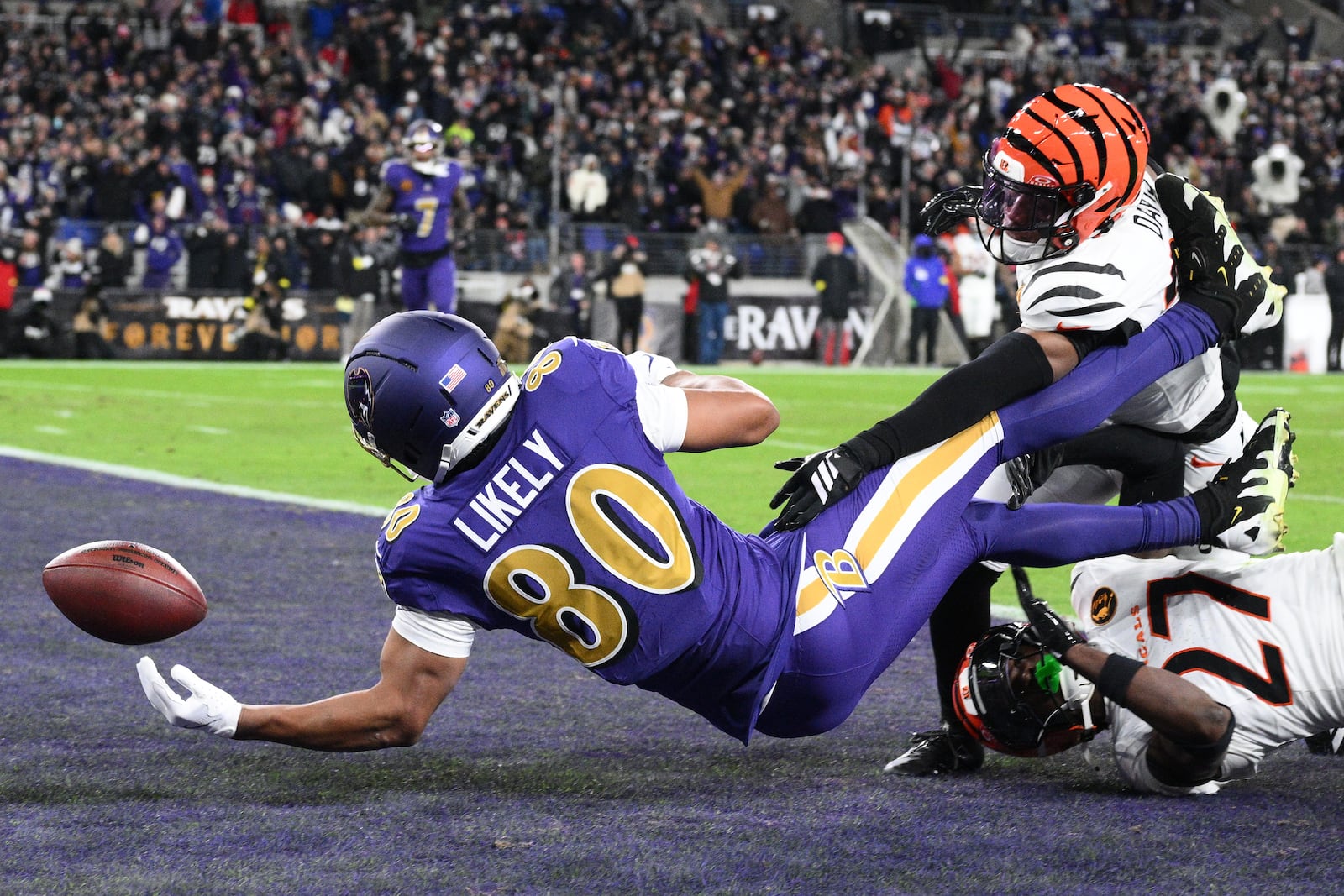 Baltimore Ravens tight end Isaiah Likely (80) fumbles the ball in the end zone as Cincinnati Bengals cornerback Jalen Davis (35) and Cincinnati Bengals safety Jordan Battle (27) defend during the first half of an NFL football game, Thursday, Nov. 27, 2025, in Baltimore. (AP Photo/Nick Wass)