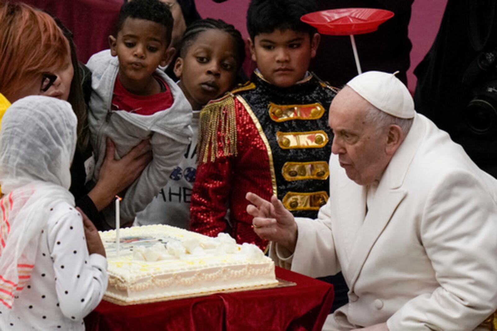 FILE - Pope Francis blows a candle on a cake as he celebrates his 87th birthday with children assisted by the Santa Marta dispensary during an audience in the Paul VI Hall, at the Vatican, Sunday, Dec. 17, 2023. (AP Photo/Alessandra Tarantino, file)