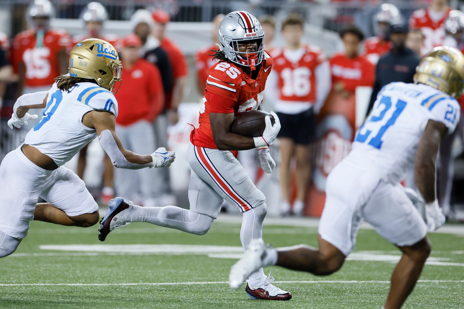 Ohio State running back Bo Jackson, center, looks for an opening against UCLA linebacker Donavyn Pellot, left, and defensive back Cole Martin, right, during the second half of an NCAA college football game, Saturday, Nov. 15, 2025, in Columbus, Ohio. (AP Photo/Jay LaPrete)