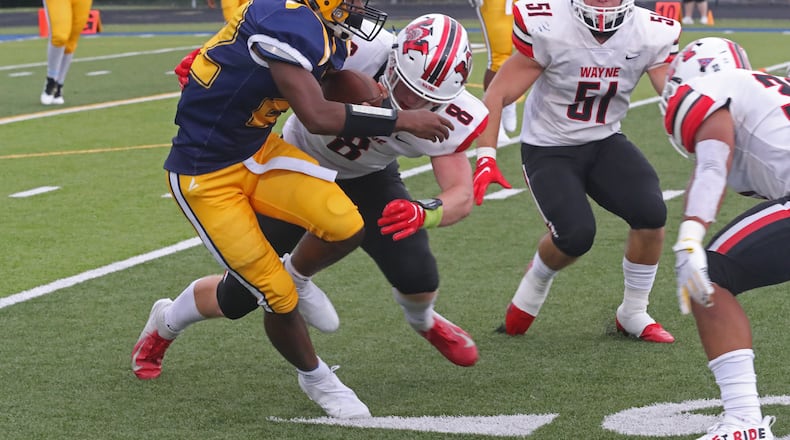 Springfield's Logan Richardson tries to avoid a tackle by Wayne's Adam Trick. BILL LACKEY/STAFF