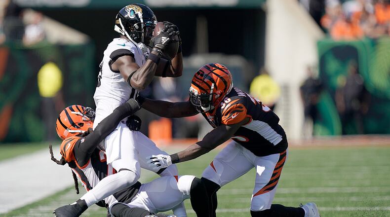 CINCINNATI, OHIO - OCTOBER 20: Chris Conley #18 of the Jacksonville Jaguars is tackled by Shawn Williams #36 and Torry McTyer #20 of the Cincinnati Bengals at Paul Brown Stadium on October 20, 2019 in Cincinnati, Ohio. (Photo by Bryan Woolston/Getty Images)