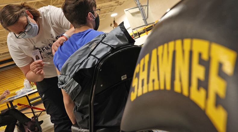 Nicole Wilson, a nurse at the Clark County Combined Health District, gives a student his COVID vaccine injection during a vaccine clinic at Shawnee High School. BILL LACKEY/STAFF