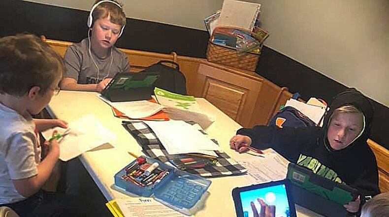 Northmont students (clockwise from left) Reid Harrison, 7, Dane Harrison, 9, Owen Sanders, 11, and Finn Harrison, 8, do schoolwork at their kitchen table at home. SUBMITTED PHOTO
