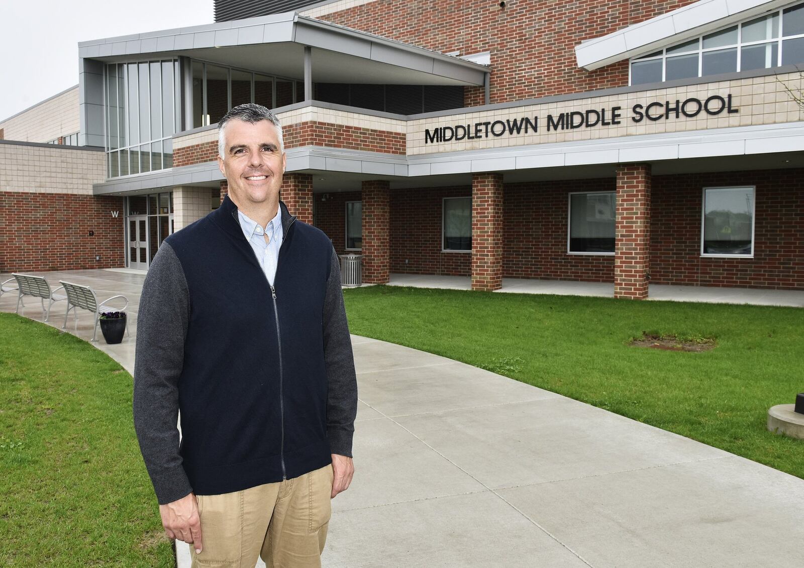 Chris Urso, president of the Middletown Board of Education, stands in front of the new Middletown Middle School, which was built with the help of state funding through the Ohio Facilities Construction Commission (OFCC). Middletown is one of a dozen local school districts helped by the OFCC but the state agency is experiencing a funding slowdown that will delay projects in Franklin and Monroe Schools.