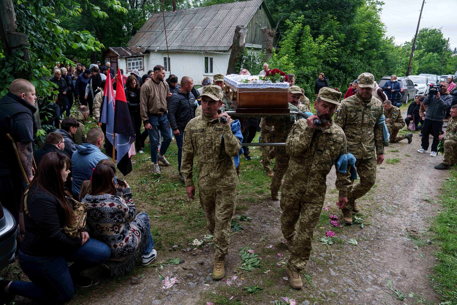 An honor guard carries the coffin of Dmytro Shapovalov, a Ukrainian serviceman, during his funeral ceremony in Yosypivka village, Vinnytsia region, Ukraine, on Friday, June 13, 2025. (AP Photo/Evgeniy Maloletka)