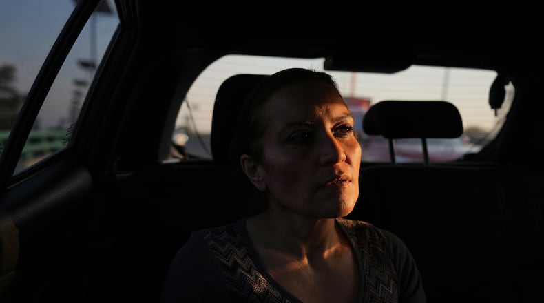 Ninfa Fuentes enters the back seat of a taxi organized by AmorrAs, a feminist transportation collective that offers rides to women who prefer alternatives to public transit due to safety concerns, in Mexico City, Thursday, Nov. 6, 2025. (AP Photo/Claudia Rosel)