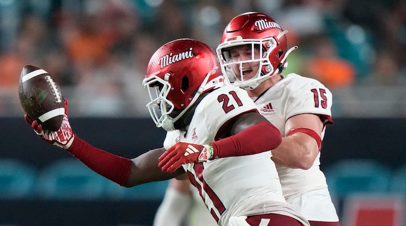 Miami (Ohio) defensive back Michael Dowell (21) celebrates with linebacker Matt Salopek (15) after Dowell intercepted the ball during the first half of an NCAA college football game against Miami, Friday, Sept. 1, 2023, in Miami Gardens, Fla. (AP Photo/Wilfredo Lee)