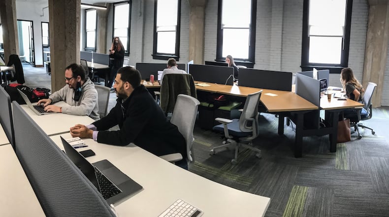 Dayton systems engineering company, Mile Two, is moving into its new offices at 601 E. Third Street. From Left, Michael Heroux and Taj Varani work in the new office, which will continue using a hybrid model of some employees working remote and others in the office. JIM NOELKER/STAFF