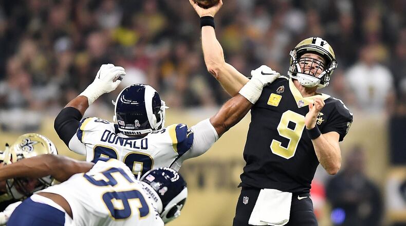 Los Angeles Rams’ Aaron Donald gets an arm on New Orleans Saints quarterback Drew Brees (9) last season. LOS ANGELES TIMES