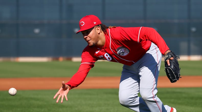 Cincinnati Reds starting pitcher Luis Castillo flips the ball to home plate during spring training baseball workouts Monday, Feb. 17, 2020, in Goodyear, Ariz. (AP Photo/Ross D. Franklin)